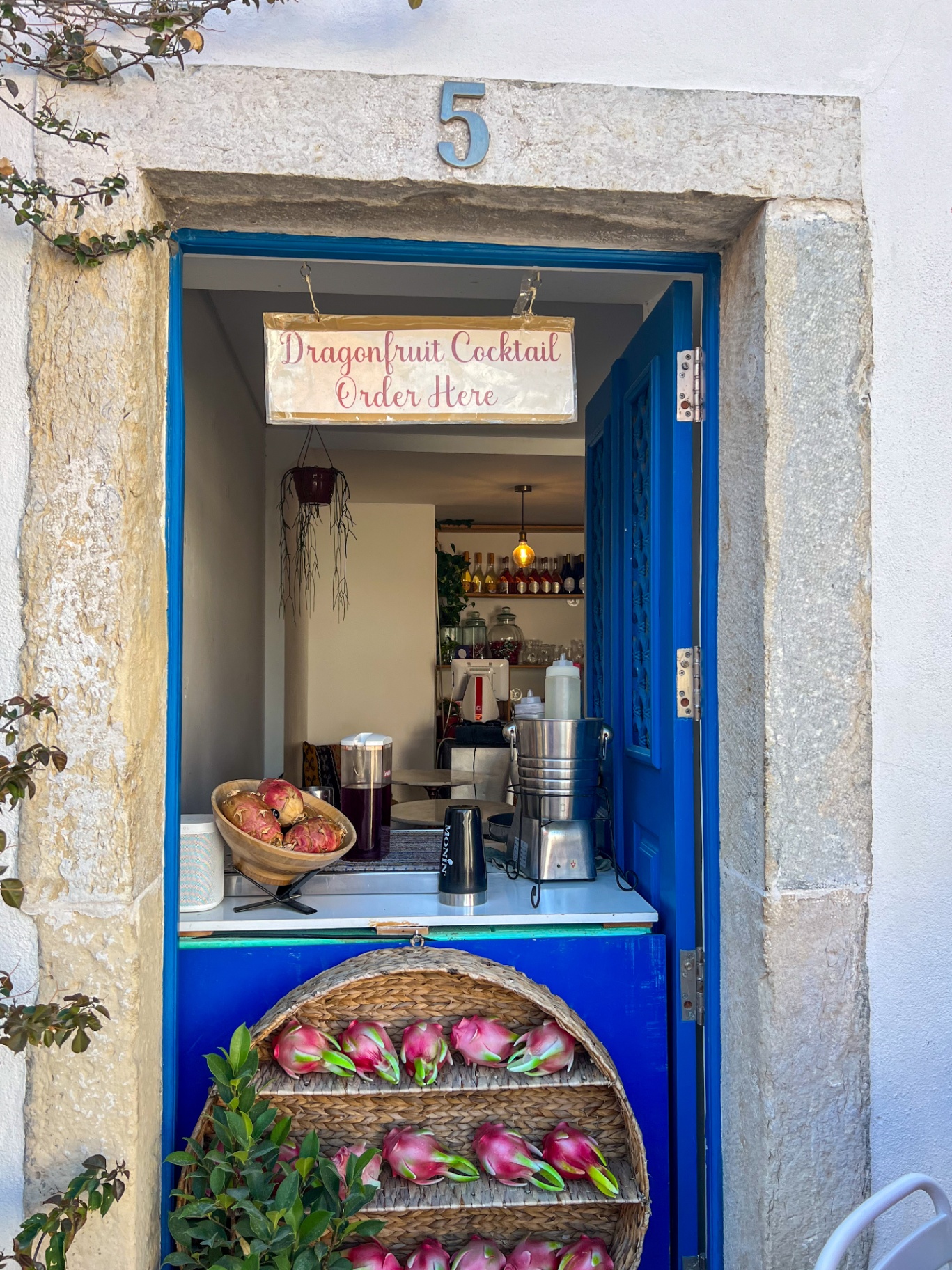 Vibrant blue doorway with fresh dragonfruit cocktails and tropical details