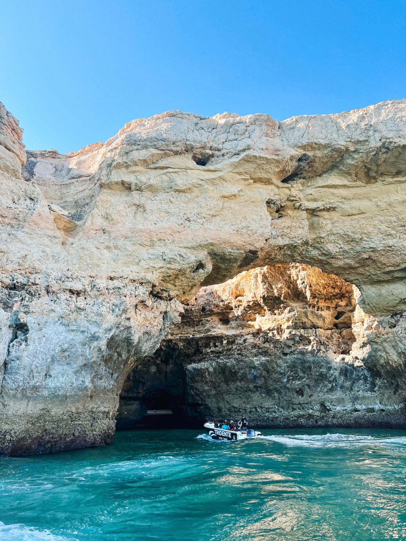 Boat tour passing limestone sea caves in the Algarve, Portugal